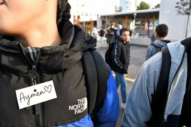 Un jeune porte une étiquette en hommage à Aymen, au collège Les Escholiers de la Mosson, où il était scolarisé, à Montpellier, le 16 décembre 2022.